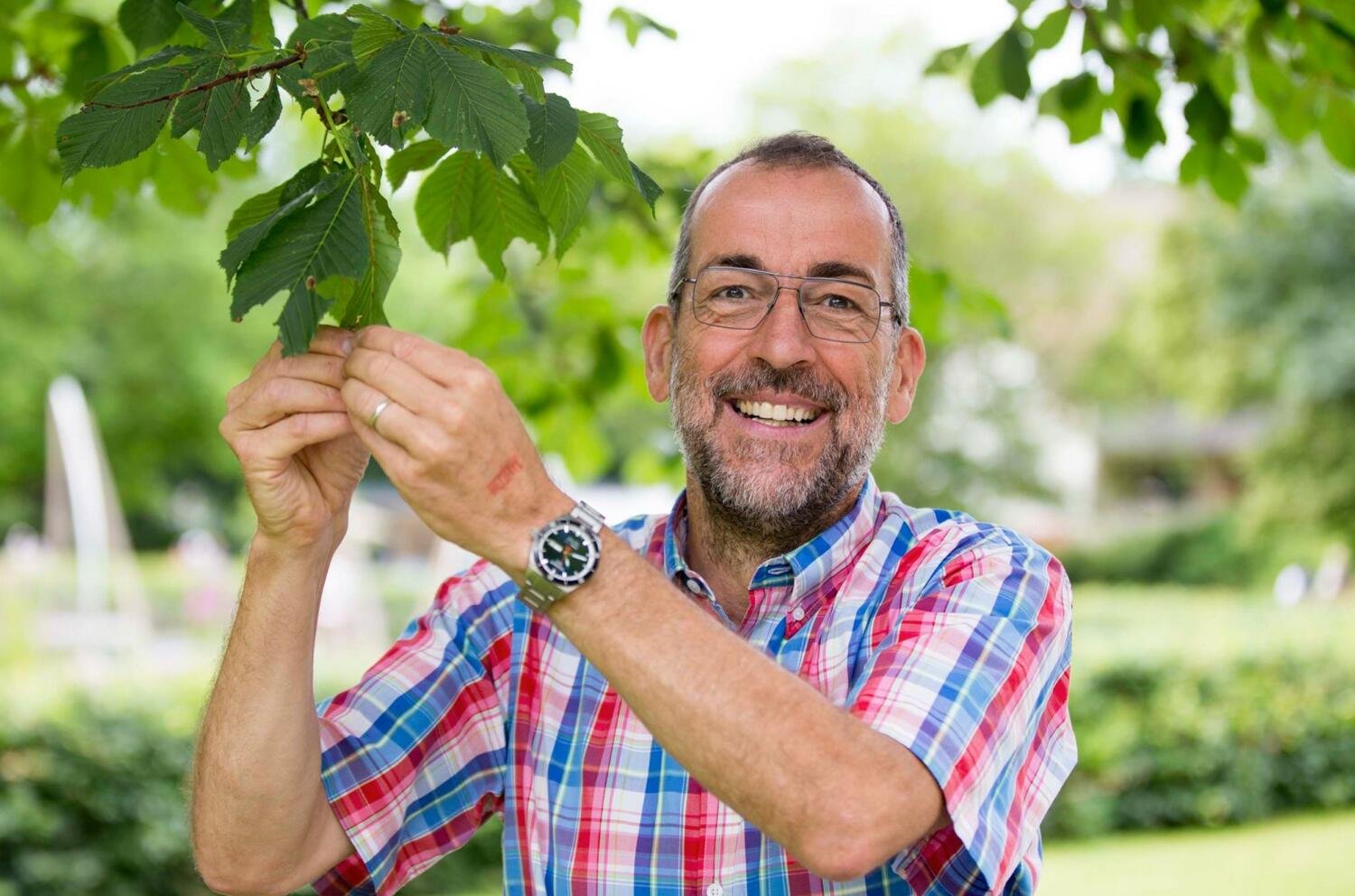 Exklusiv-Führung Gartenschau Volker Kugel steht unter einem Baum und lächelt in die Kamera.